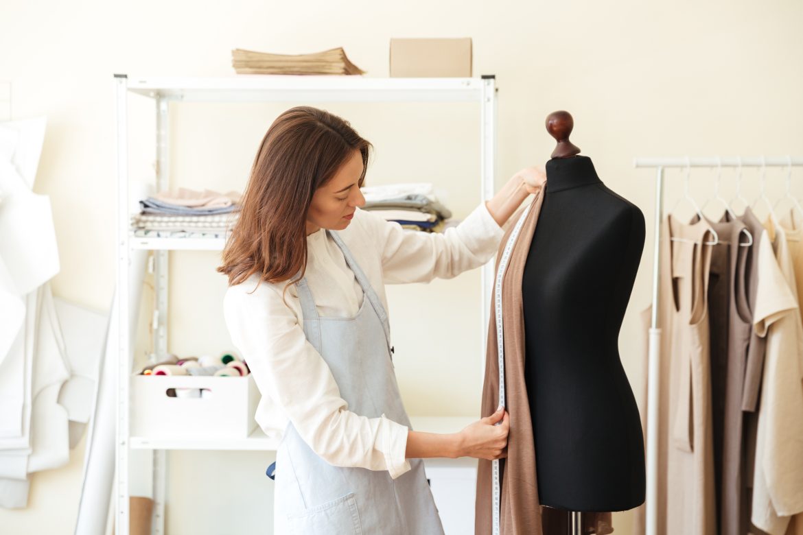 Seamstress measuring fabric on black dummy Finding the Perfect Fit: The Importance of Tailoring for Men’s Clothing